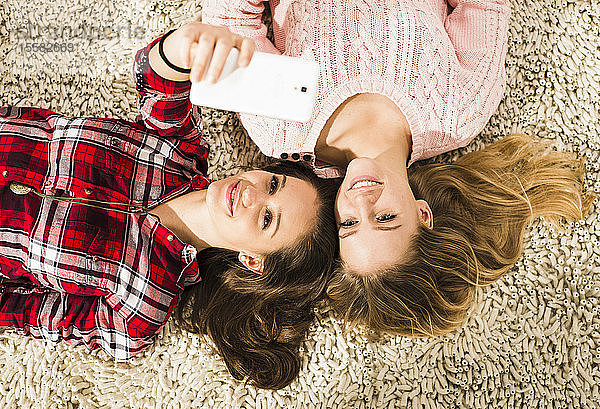 Zwei Freundinnen beim Selfie mit Smartphone zu Hause