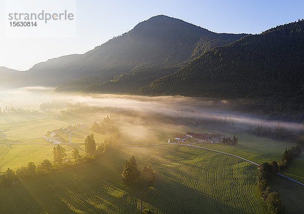 Deutschland,  Bayern,  Oberbayern,  Isarwinkel,  Jachenau,  ländliche Landschaft im Nebel bei Sonnenaufgang