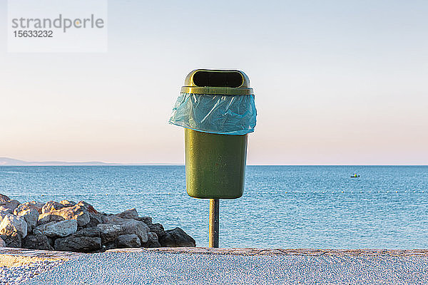 Kroatien,  Krk,  Mülleimer gegen ruhiges Meer