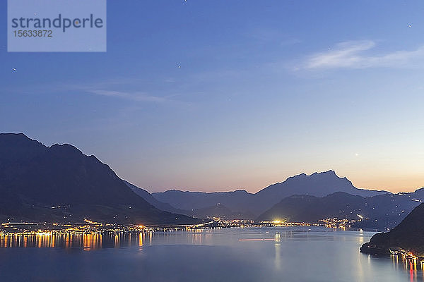 Schweiz,  Gersau,  Schwyz,  Beleuchtete Häuser entlang der Küste des Vierwaldstättersees in der Abenddämmerung