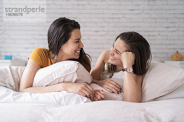 Glückliches lesbisches Paar liegt im Bett