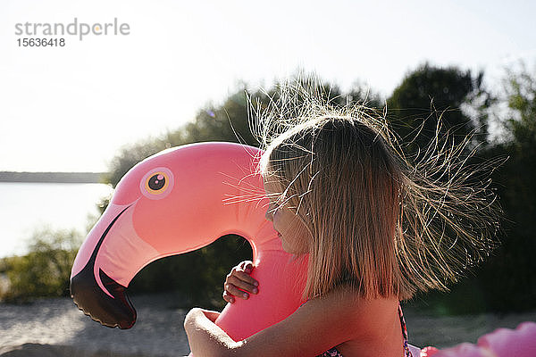 Mädchen umarmender Flamingo-Poolwagen