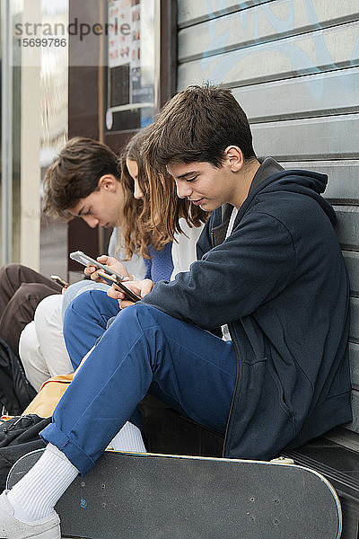 Freunde benutzen ihr Smartphone im Freien