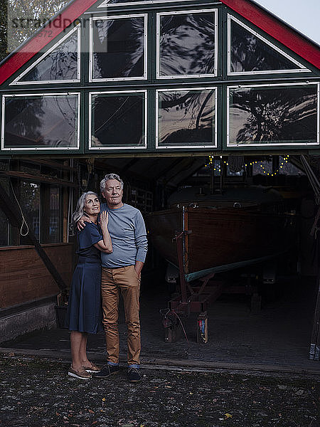 Älteres Ehepaar steht vor dem Bootshaus