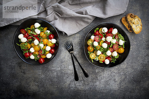 Draufsicht auf Salat mit Rucola,  Mozzarella,  Kirschtomaten und Basilikum