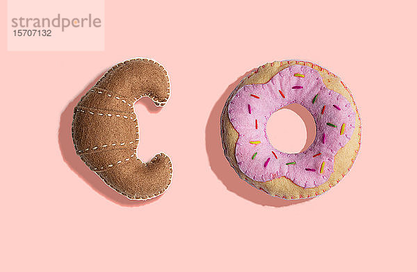 3D-Illustration,  Plüschimitat-Croissant- und Donut-Muster auf hellrosa Hintergrund