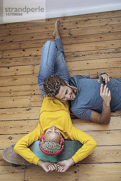 Junges Paar liegt zu Hause auf dem Boden und entspannt sich