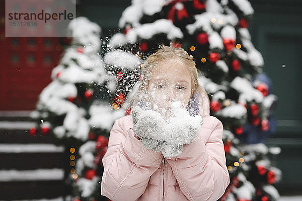 Kleines Mädchen bläst Schnee