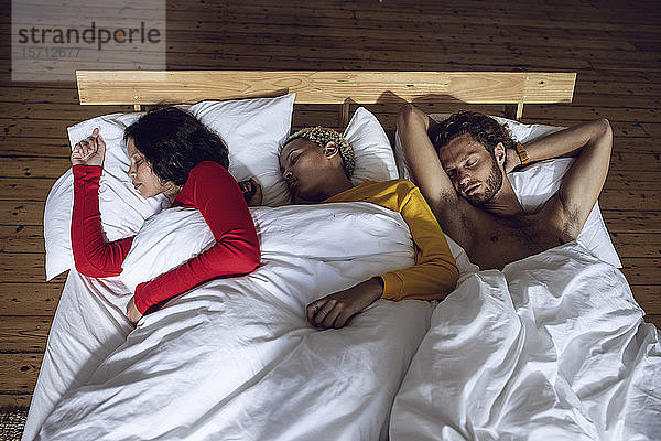 Drei Freunde schlafen zu Hause im Bett