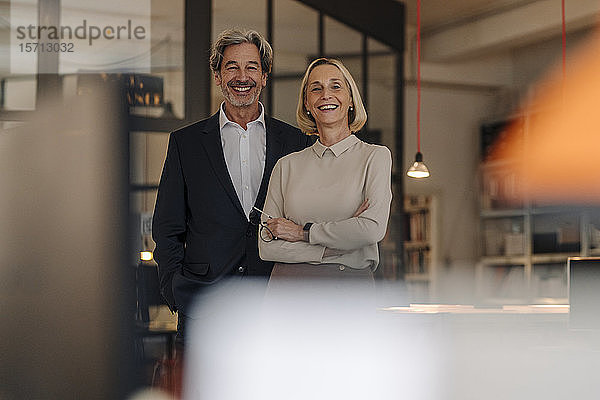 Porträt eines lächelnden Geschäftsmannes und einer lächelnden Geschäftsfrau im Amt