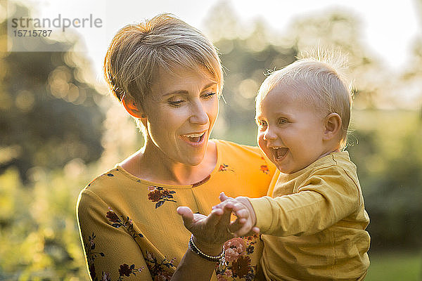 Porträt einer glücklichen Mutter mit ihrem kleinen Sohn im Gegenlicht