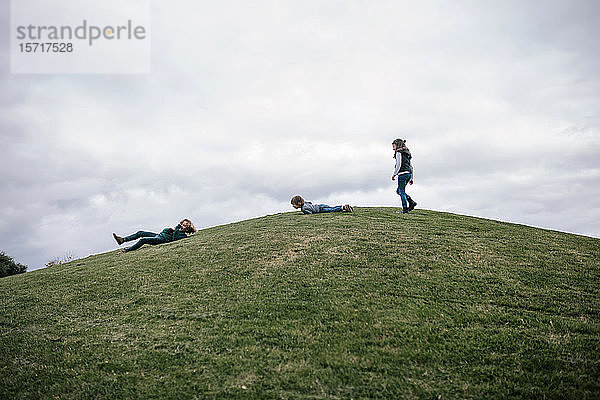 Drei Kinder spielen auf einem Hügel