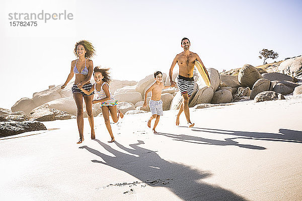 Glückliche Familie läuft am Strand