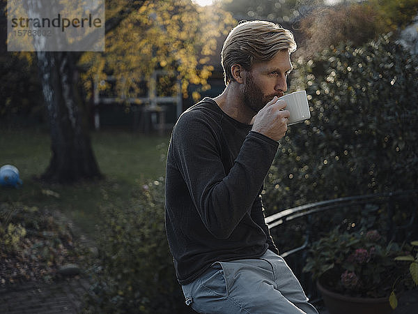 Mann bei einer Kaffeepause im Garten