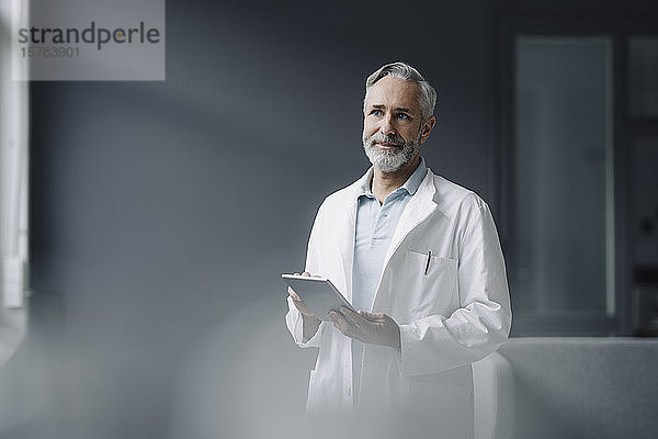 Portrait eines Arztes mit digitalem Tablett aus der Ferne