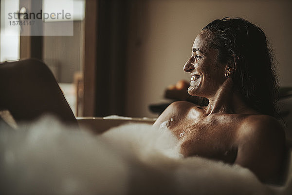Glückliche Frau entspannt sich in der Badewanne