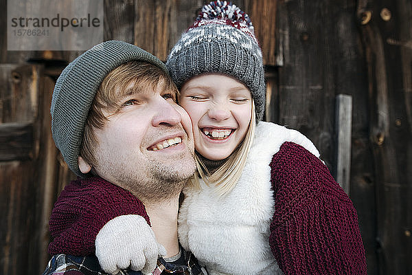 Glücklicher Vater mit Tochter im Winter im Freien