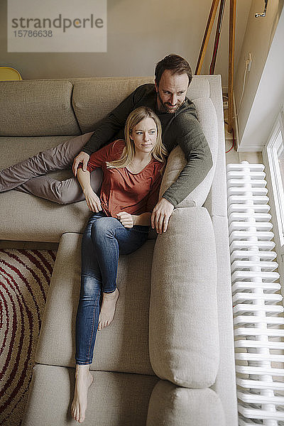 Paar sitzt zu Hause auf der Couch und entspannt