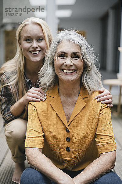 Porträt einer glücklichen Mutter und einer erwachsenen Tochter auf der Terrasse