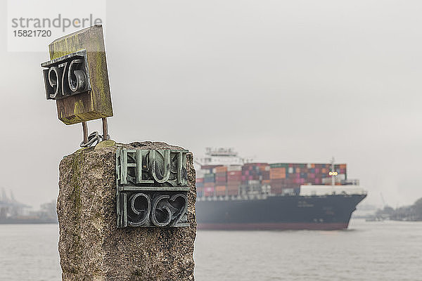 Deutschland,  Hamburg,  Küstenhochwasser-Denkmal mit Containerschiff im Hintergrund