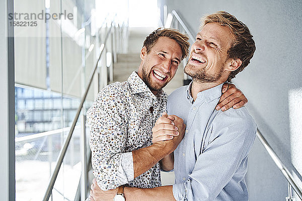 Porträt von zwei glücklichen jungen Geschäftsleuten beim Händeschütteln