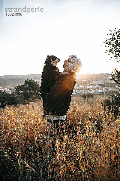 Junger Mann mit seinem Hund bei Sonnenaufgang,  Montroy,  Spanien