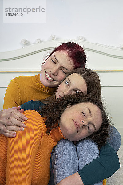 Porträt von drei Schwestern,  die sich aneinander kuscheln
