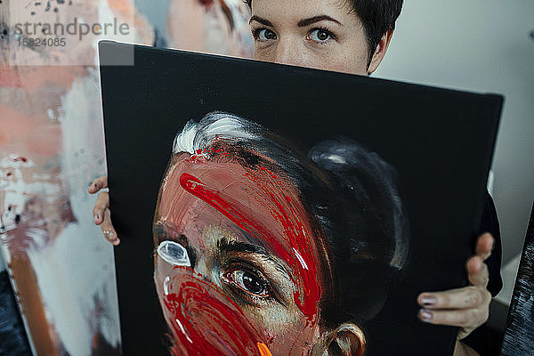 Porträt einer Malerin mit Malerei in ihrem Atelier