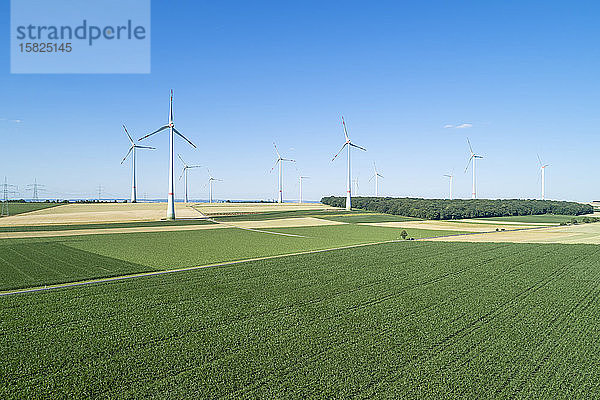 Deutschland,  Bayern,  Drone-Ansicht grüner Landschaftsfelder im Sommer mit Windpark im Hintergrund