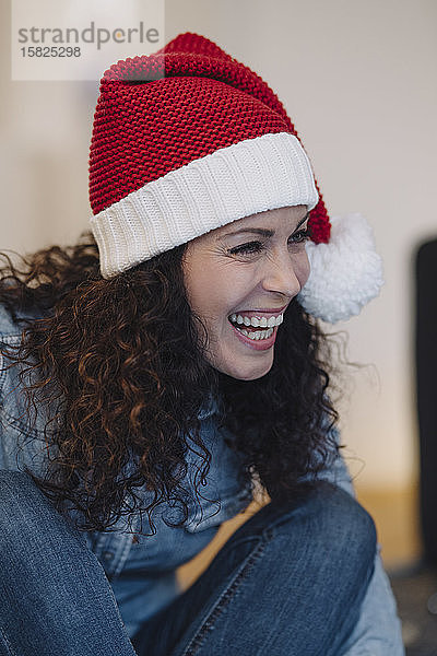 Porträt einer lachenden Frau mit Weihnachtsmannhut