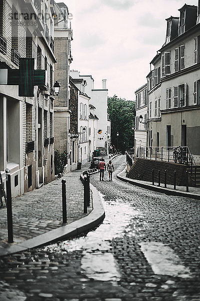 Menschen laufen bei bewölktem Himmel durch die Straßen von Paris