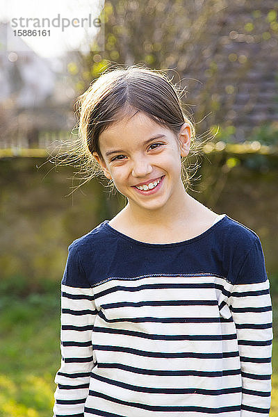 Porträt eines lächelnden Mädchens im Garten