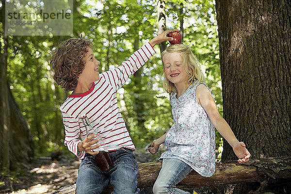 Lächelnde Kinder spielen im Wald