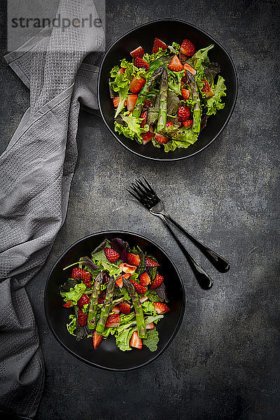 Zwei Schalen mit vegetarischem Salat mit Salat,  Erdbeeren und Spargel