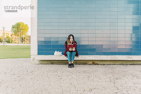 Teenager-Mädchen liest im Freien ein Buch