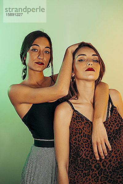Porträt von zwei jungen Frauen vor grünem Hintergrund