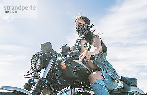 Junge schöne Frau beim Motorradfahren