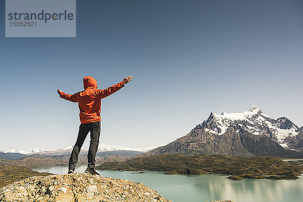 Wanderer hebt seine Arme in der Berglandschaft am Lago Pehoe im Torres del Paine Nationalpark,  Patagonien,  Chile