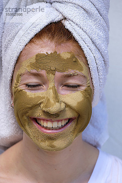 Porträt einer lachenden Teenagerin mit Gesichtsmaske