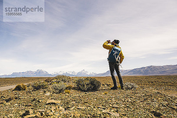 Wanderer trinkt aus der Flasche in einer abgelegenen Landschaft in Patagonien,  Argentinien