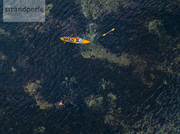 Indonesien,  Bali,  Sanur,  Luftaufnahme von zwei Kajakfahrern,  die an einem Mann vorbeifahren,  der im flachen Wasser fischt