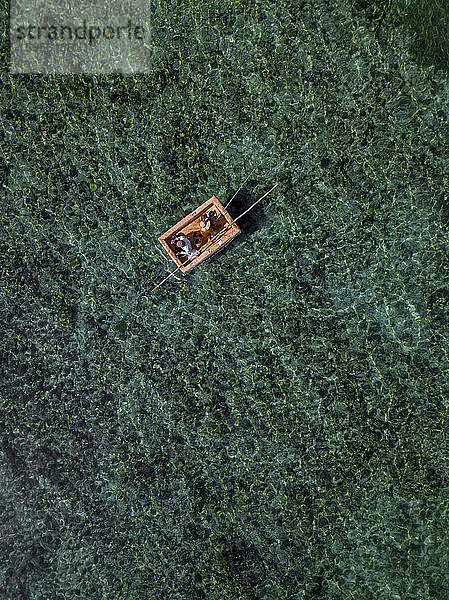 Indonesien,  Bali,  Nusa Dua,  Luftaufnahme von zwei Personen,  die auf einem Boot in der Nähe des Gunung Payung Strandes fischen
