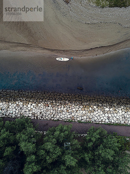 Indonesien,  Bali,  Sanur,  Luftaufnahme eines Mannes mit Kanu am sandigen Flussufer