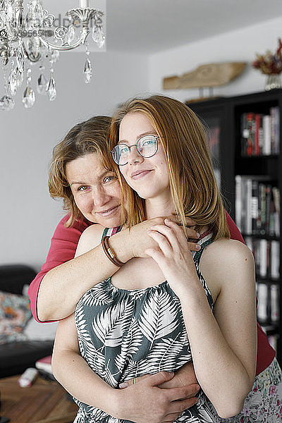 Mutter umarmt ihre erwachsene Tochter zu Hause