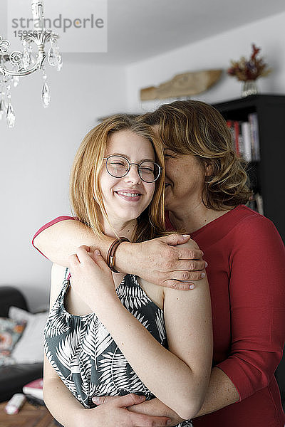 Mutter umarmt ihre erwachsene Tochter zu Hause