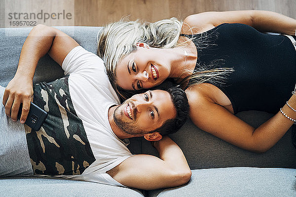 Porträt eines glücklichen Paares,  das sich gemeinsam auf der Couch entspannt