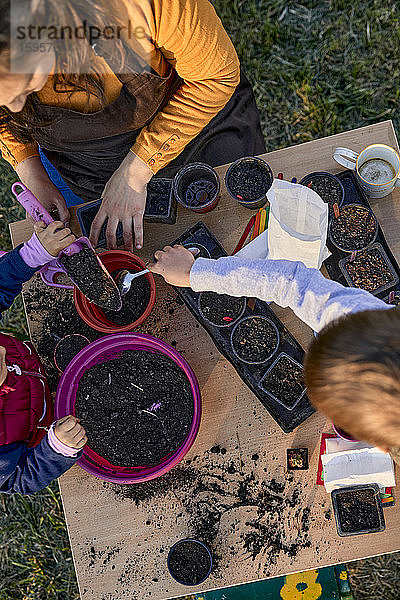 Mutter mit zwei Kindern bei der Gartenarbeit