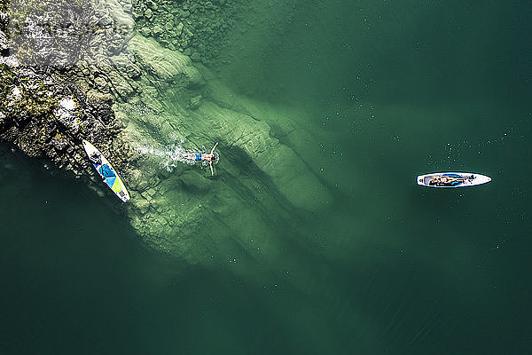 Deutschland,  Bayern,  Luftaufnahme von zwei Paddelboardern,  die sich am grünen Ufer des Walchensees entspannen