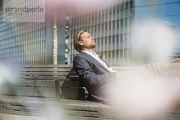 Geschäftsmann entspannt sich auf einer Bank in der Stadt
