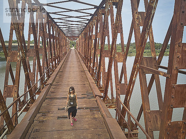 Benin,  Grand Popo,  Touristin über rostige Eisenbrücke